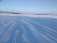 Winterlandschaft mit dem Schatten einer Radlerin im Vordergrund