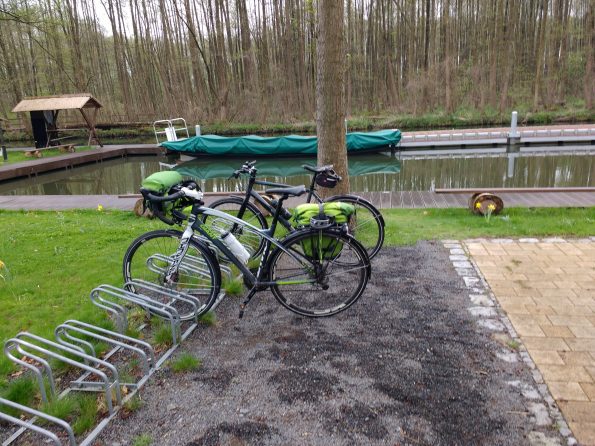 Zwei Fahrräder vor einem kleinen Hafenbecken mit Spreekähnen