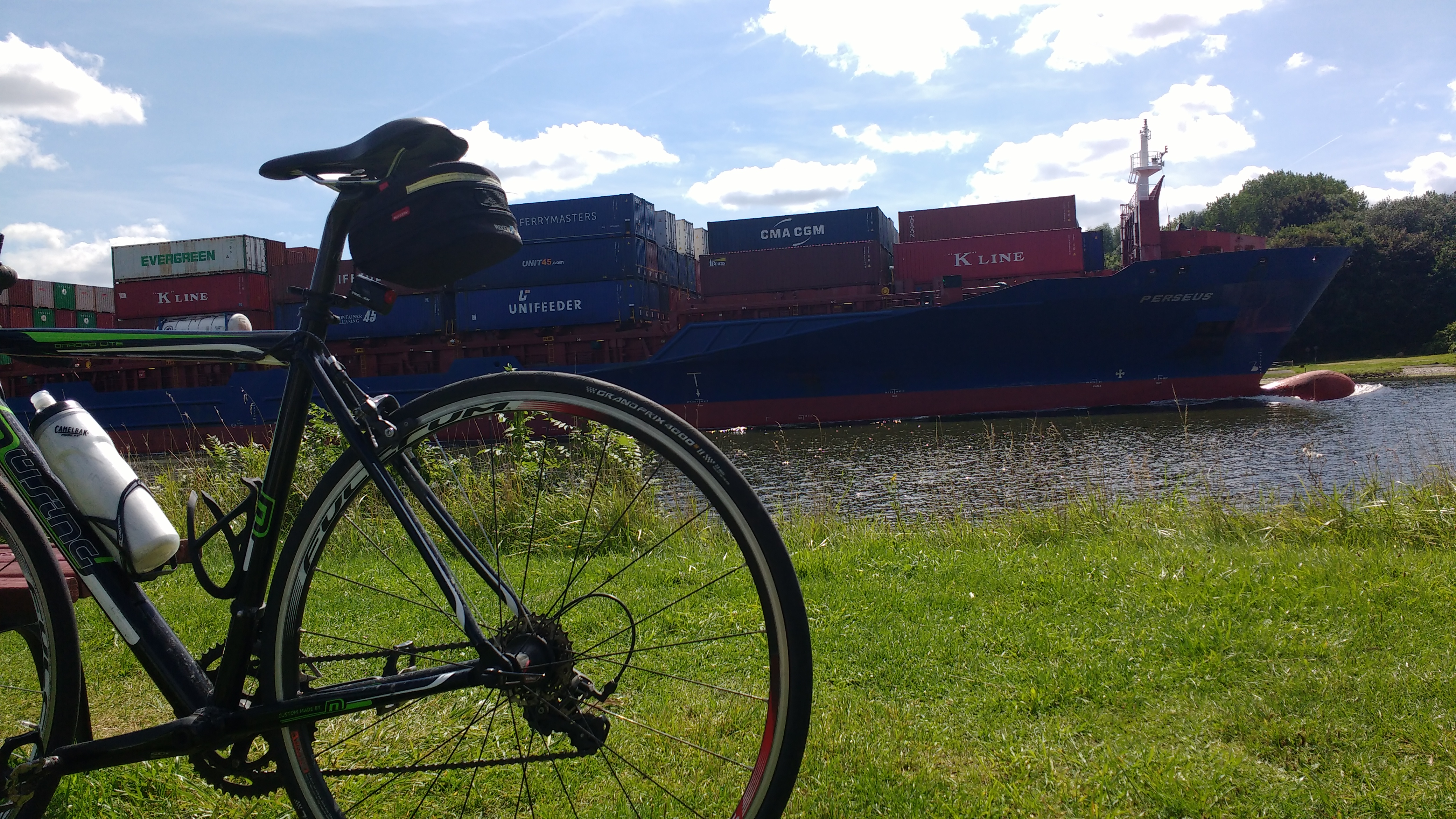 Mein Rad vor dem Nord-Ostsee-Kanal, und ein großer Frachter dahinter