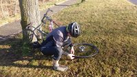 Mann in Rennradkleidung repariert einen platten Reifen.
